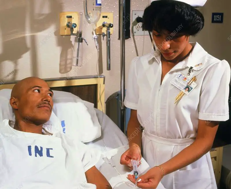 Nurse giving IV drug to cancer patient